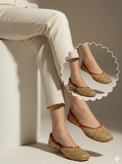 Person wearing floral-patterned flats with light-colored pants against a neutral background