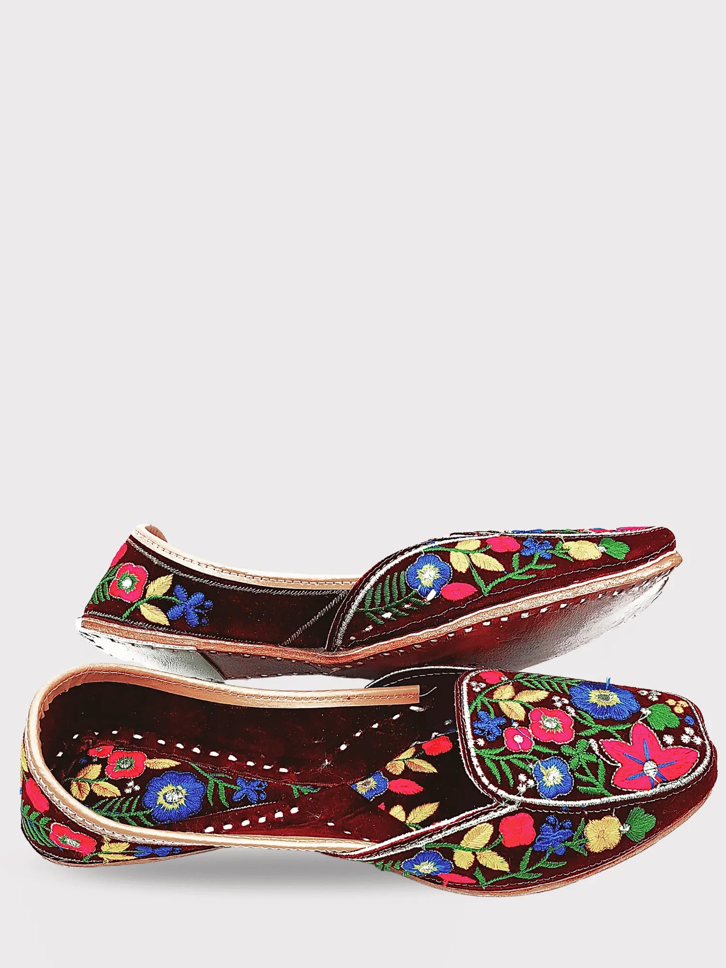 Pair of brown shoes with colorful floral embroidery on a white background