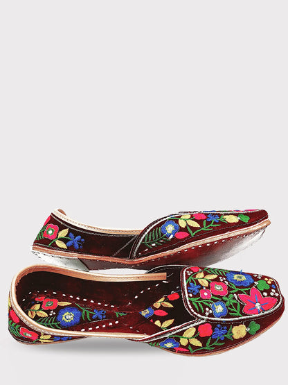 Pair of brown shoes with colorful floral embroidery on a white background