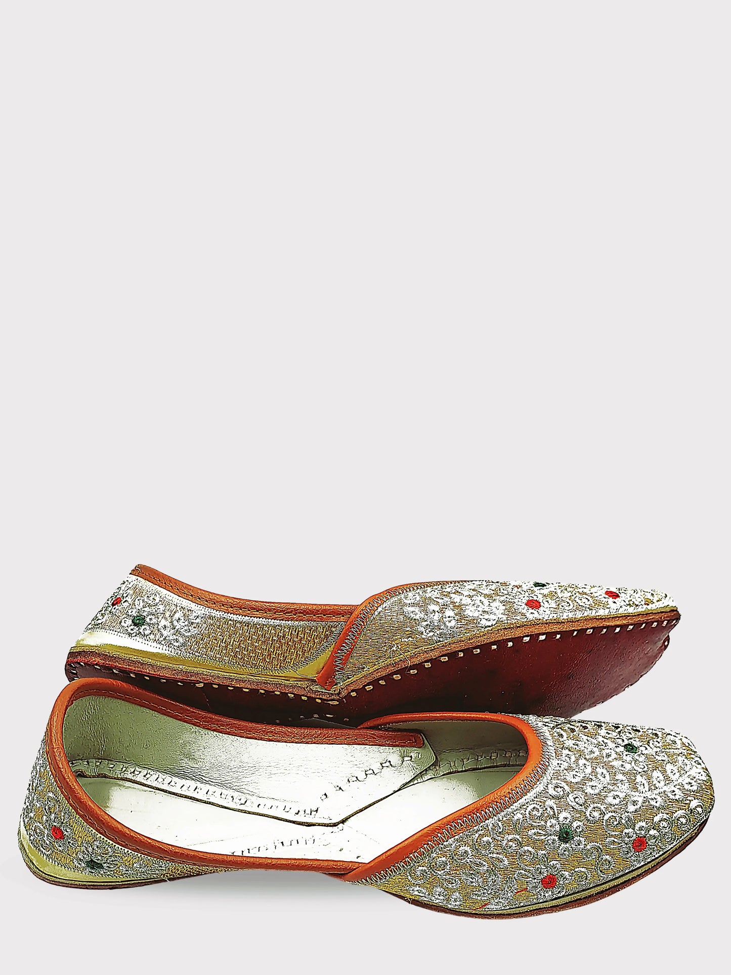 Pair of ornate shoes with intricate designs on a white background