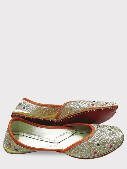 Pair of ornate shoes with intricate designs on a white background